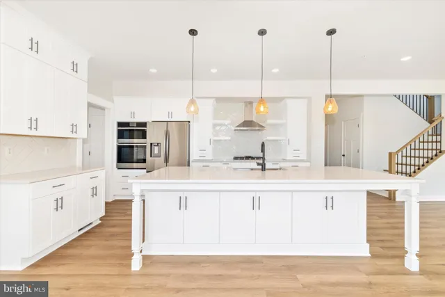 a kitchen with kitchen island granite countertop a sink a counter top space and cabinets