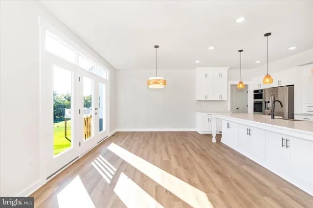 a view of a kitchen with wooden floor and windows