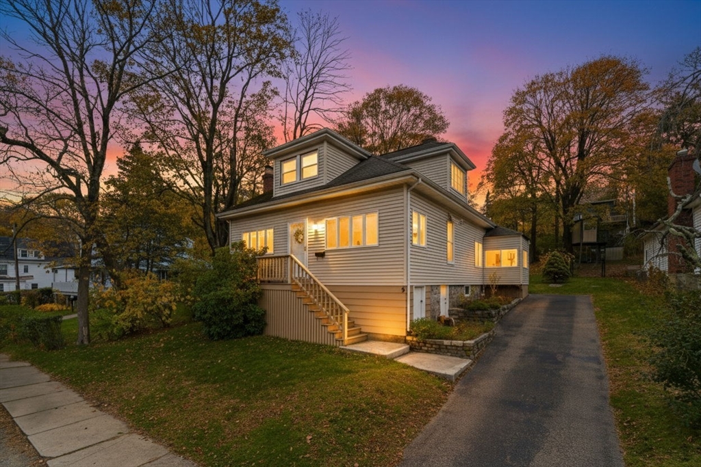 a front view of a house with a yard and trees