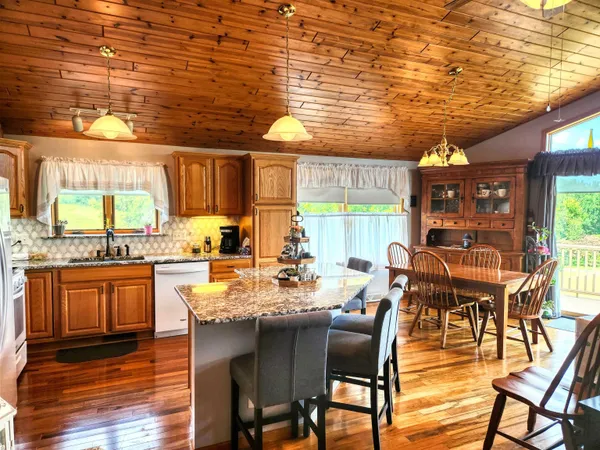 a dining room with furniture a chandelier and wooden floor
