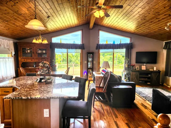 a kitchen with stainless steel appliances kitchen island granite countertop a table chairs and a refrigerator