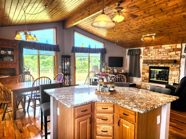a dining hall with stainless steel appliances granite countertop a stove and cabinets