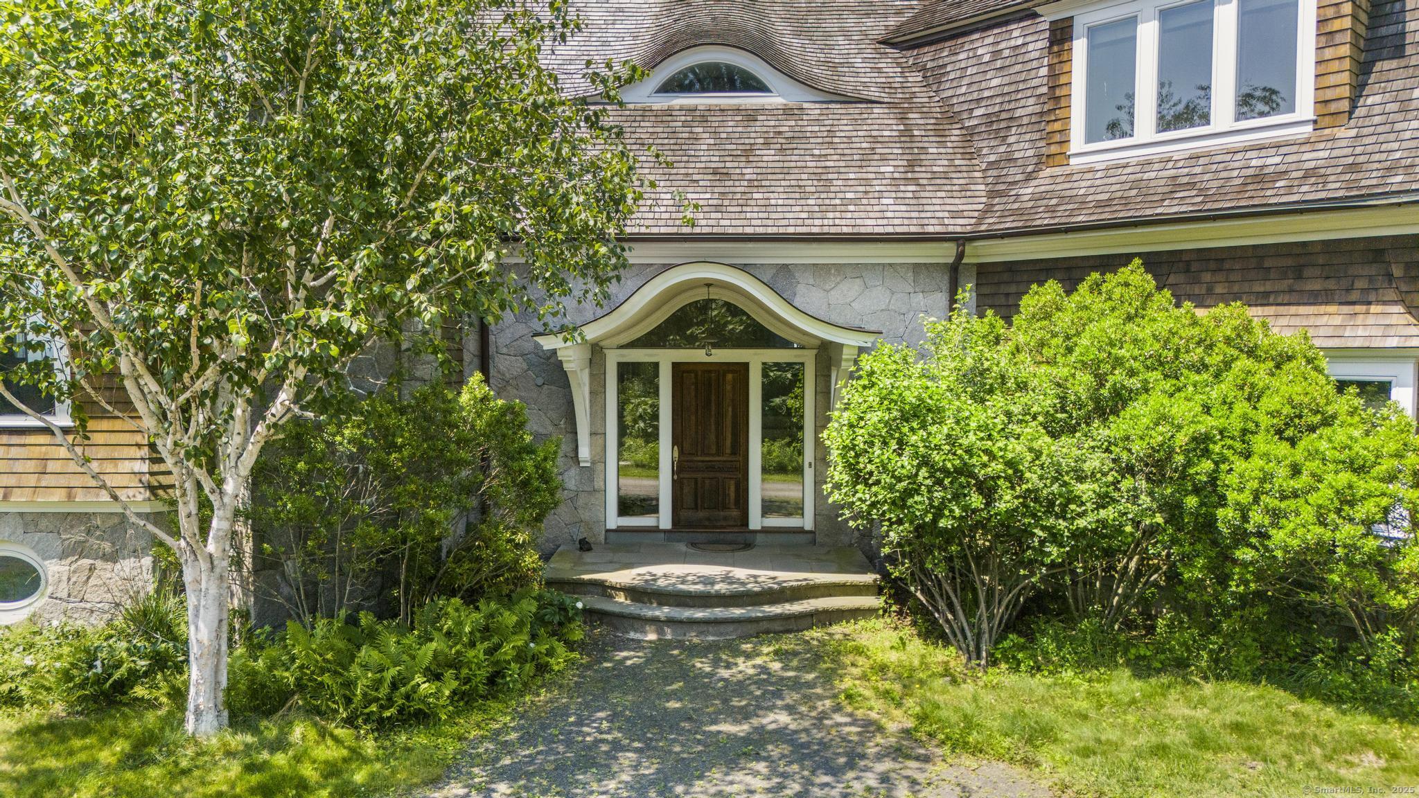 1410 South Pine Creek Road Fairfield, CT 06824 - Photo 11 of 40 a front view of a house with a garden