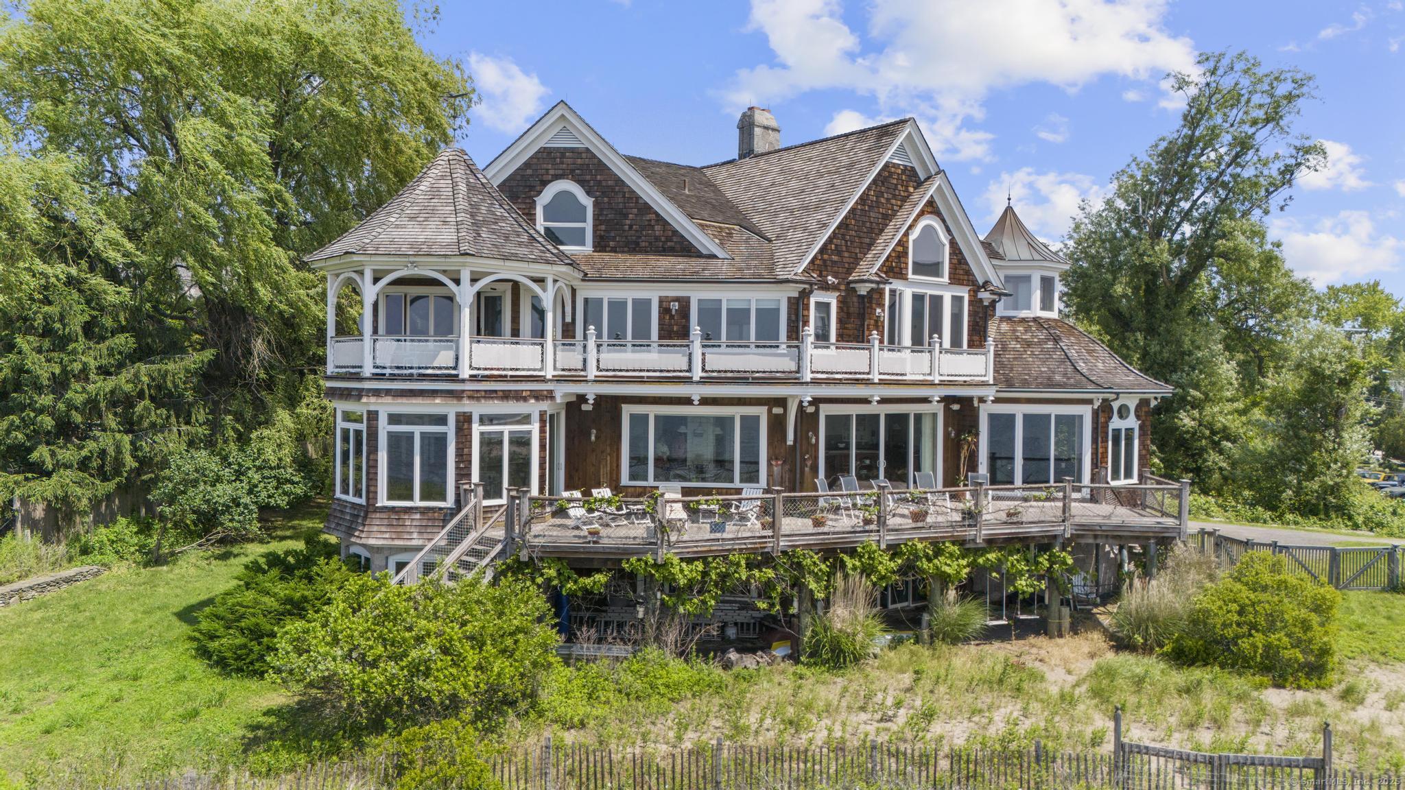 1410 South Pine Creek Road Fairfield, CT 06824 - Photo 16 of 40 a front view of a house with a yard and potted plants
