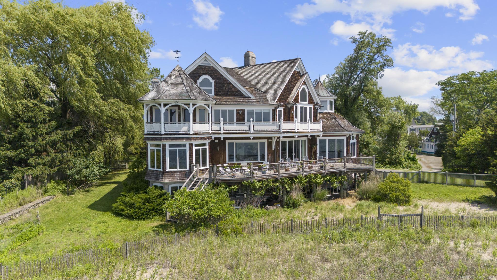 1410 South Pine Creek Road Fairfield, CT 06824 - Photo 2 of 40 a front view of a house with a yard and potted plants
