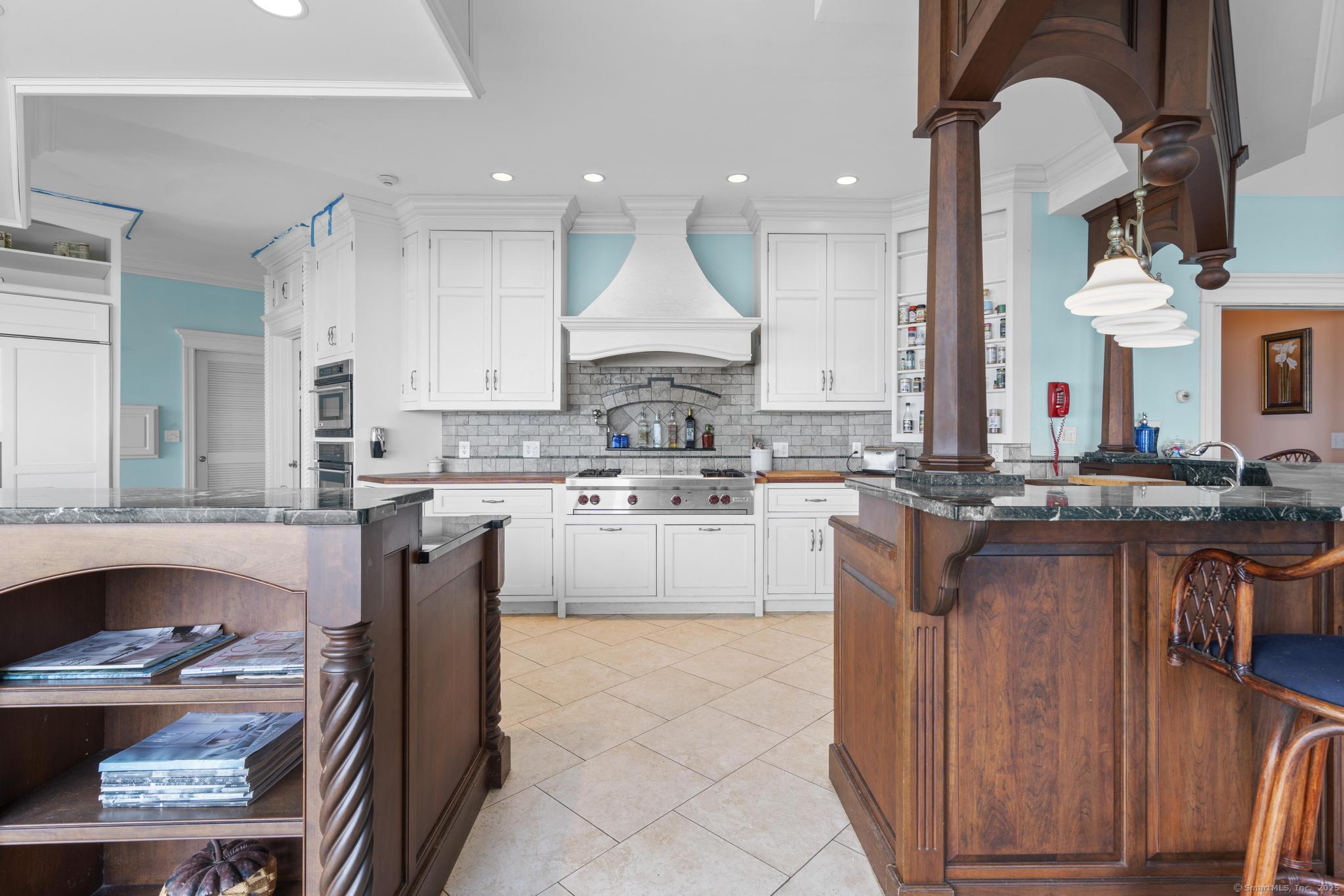 1410 South Pine Creek Road Fairfield, CT 06824 - Photo 26 of 40 a kitchen with kitchen island granite countertop a stove and a sink