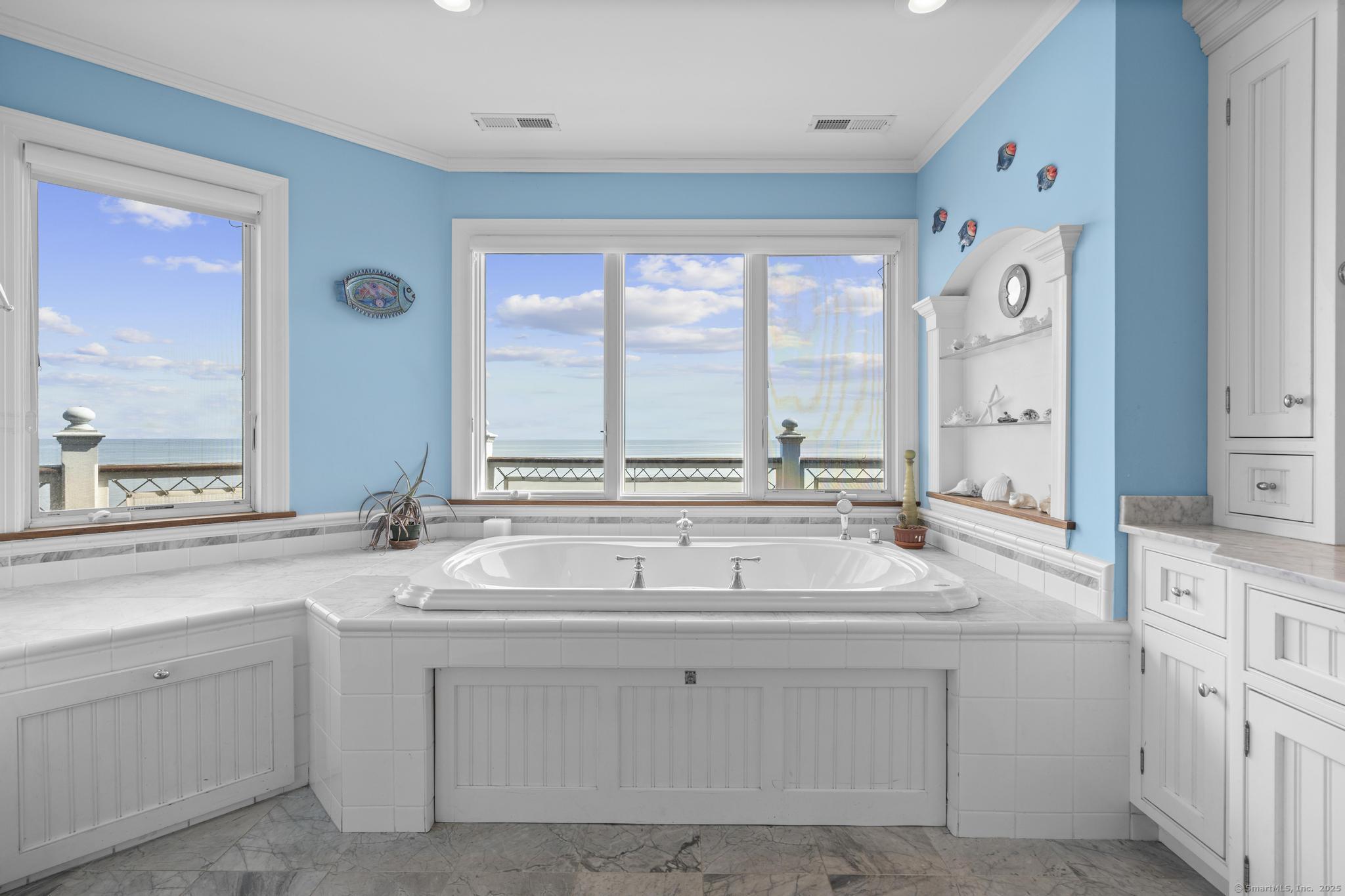 1410 South Pine Creek Road Fairfield, CT 06824 - Photo 39 of 40 a bathroom with a sink and a large mirror next to a window