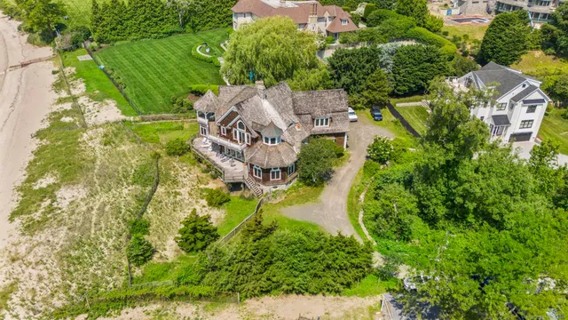 an aerial view of residential house with outdoor space and trees all around