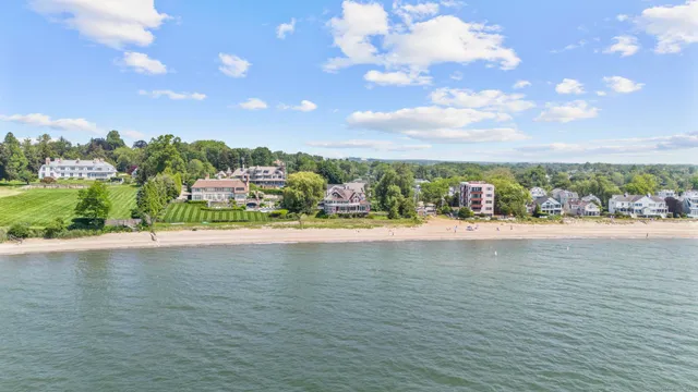 an aerial view of a house with outdoor space swimming pool lake and green space