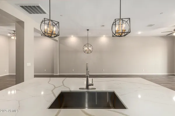 a view of an empty room with wooden floor and windows