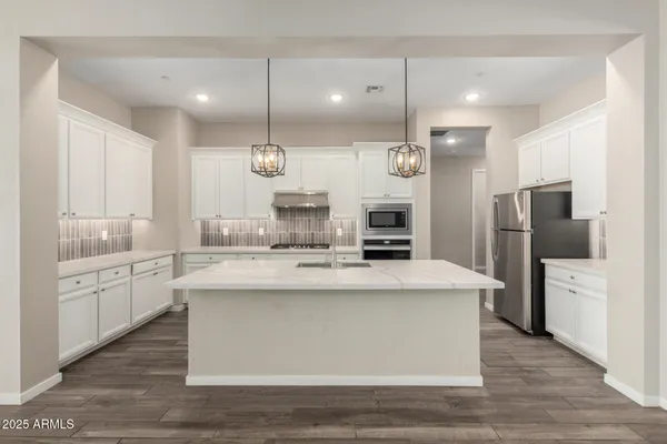 a kitchen with a sink a stove a refrigerator and chairs