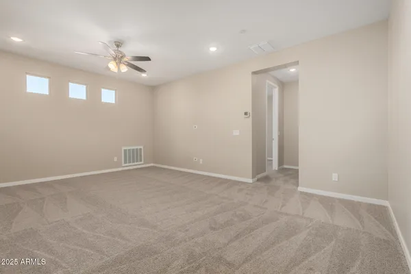 an empty room with a window and a fan