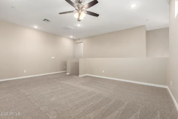 an empty room with chandelier fan