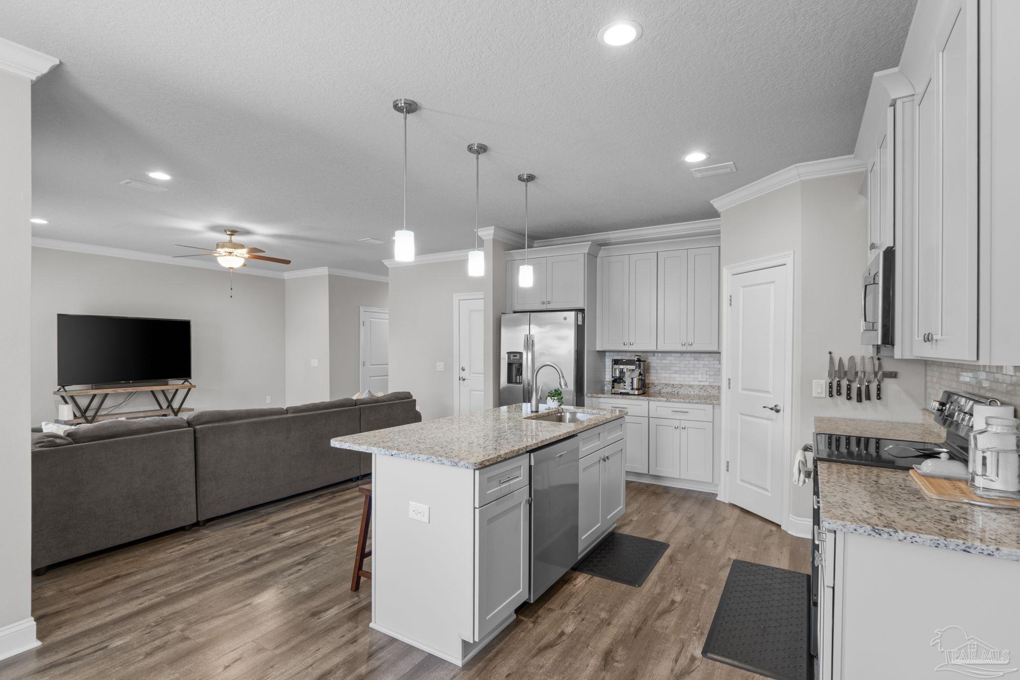 2770 Joe Pruitt Road Navarre, FL 32566 - Photo 14 of 58 a view of a kitchen with kitchen island a sink stainless steel appliances and cabinets