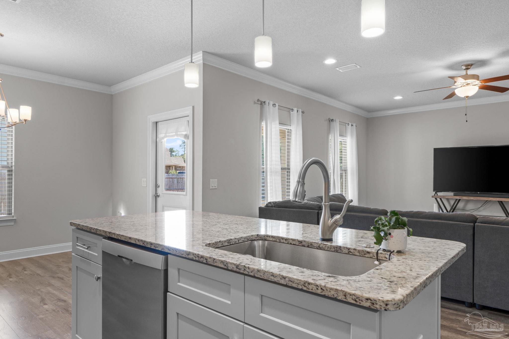 2770 Joe Pruitt Road Navarre, FL 32566 - Photo 17 of 58 a kitchen with granite countertop a sink and a refrigerator