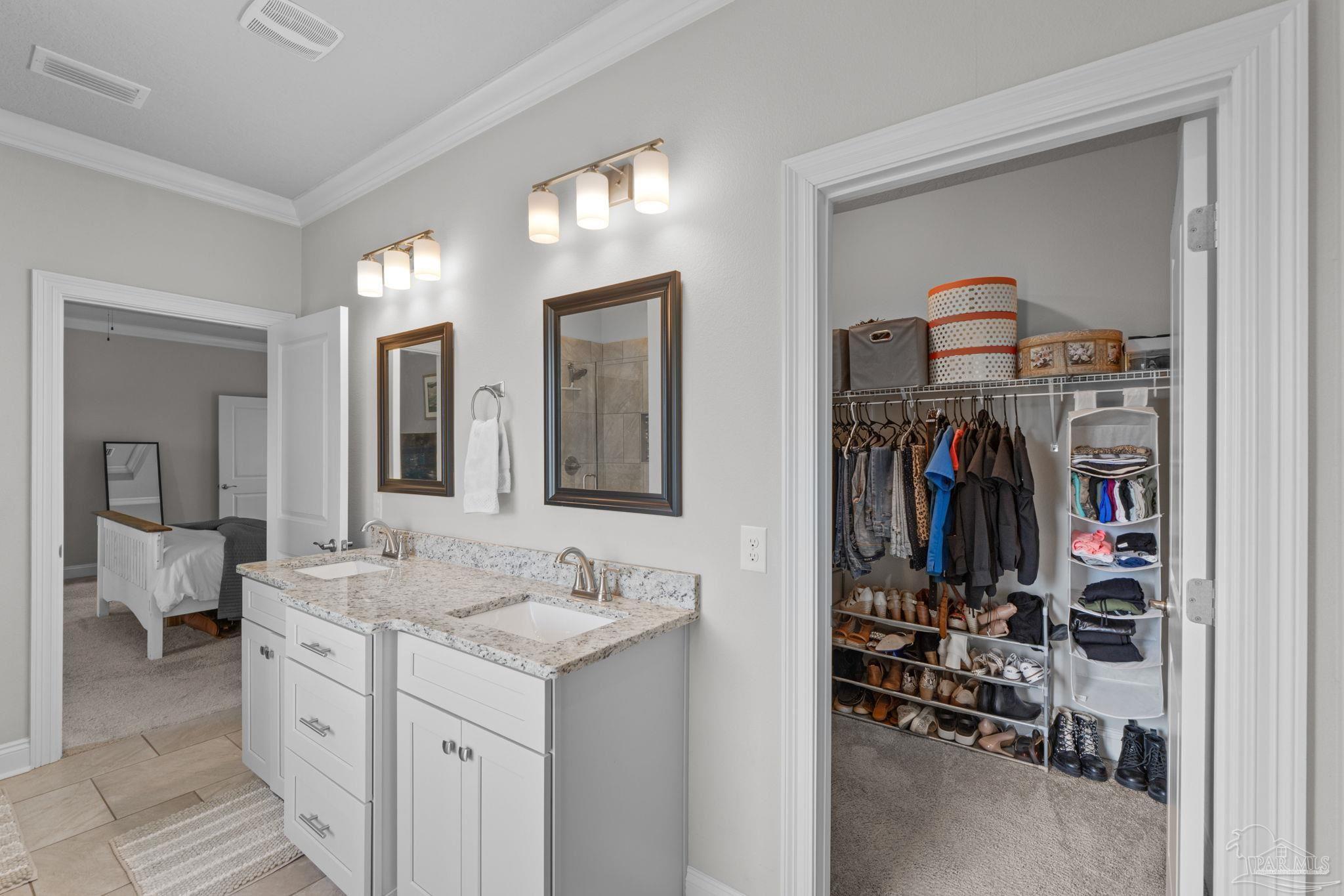 2770 Joe Pruitt Road Navarre, FL 32566 - Photo 30 of 58 a en suite bathroom with a double vanity sink and a mirror