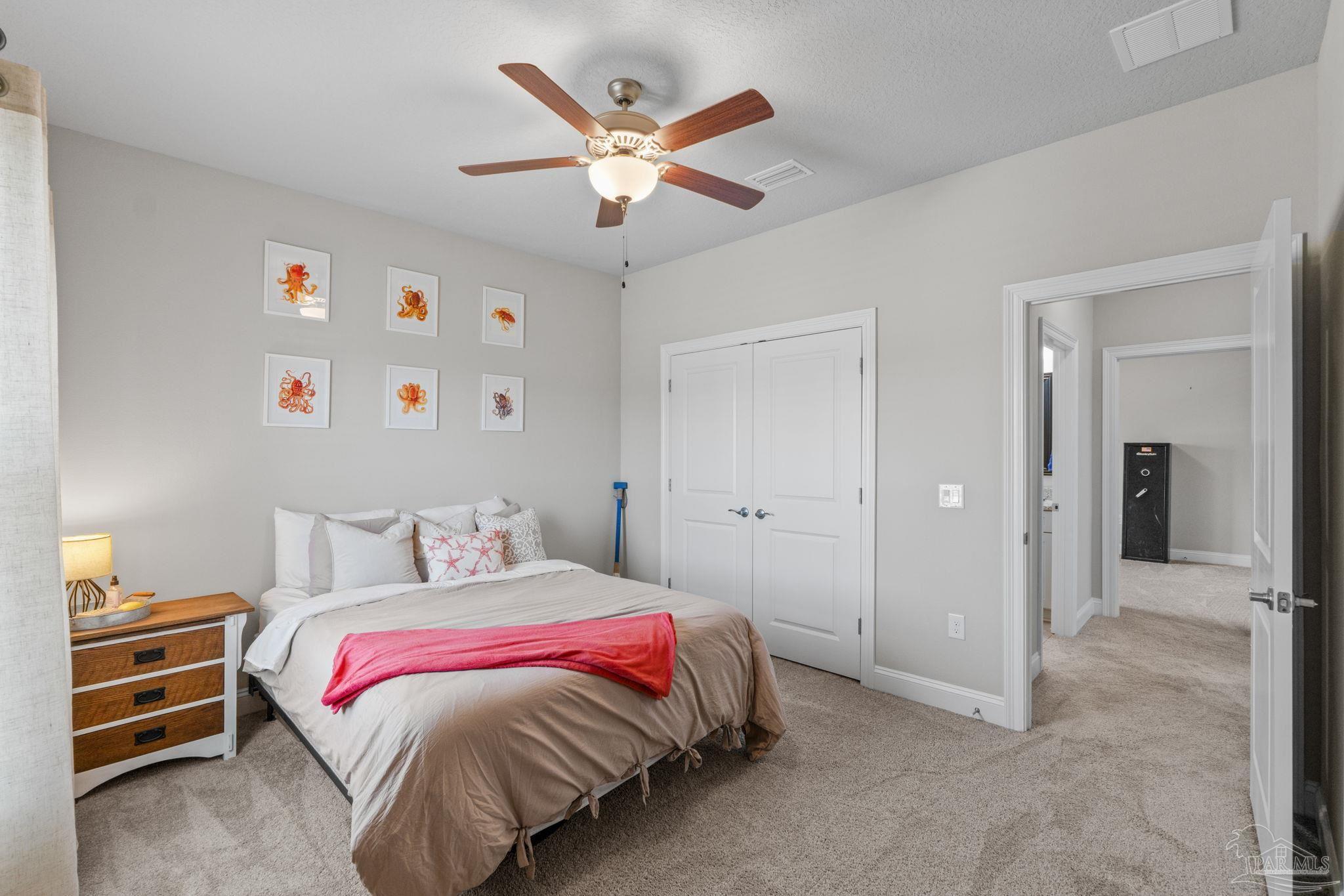 2770 Joe Pruitt Road Navarre, FL 32566 - Photo 38 of 58 a bedroom with a large bed and a chandelier