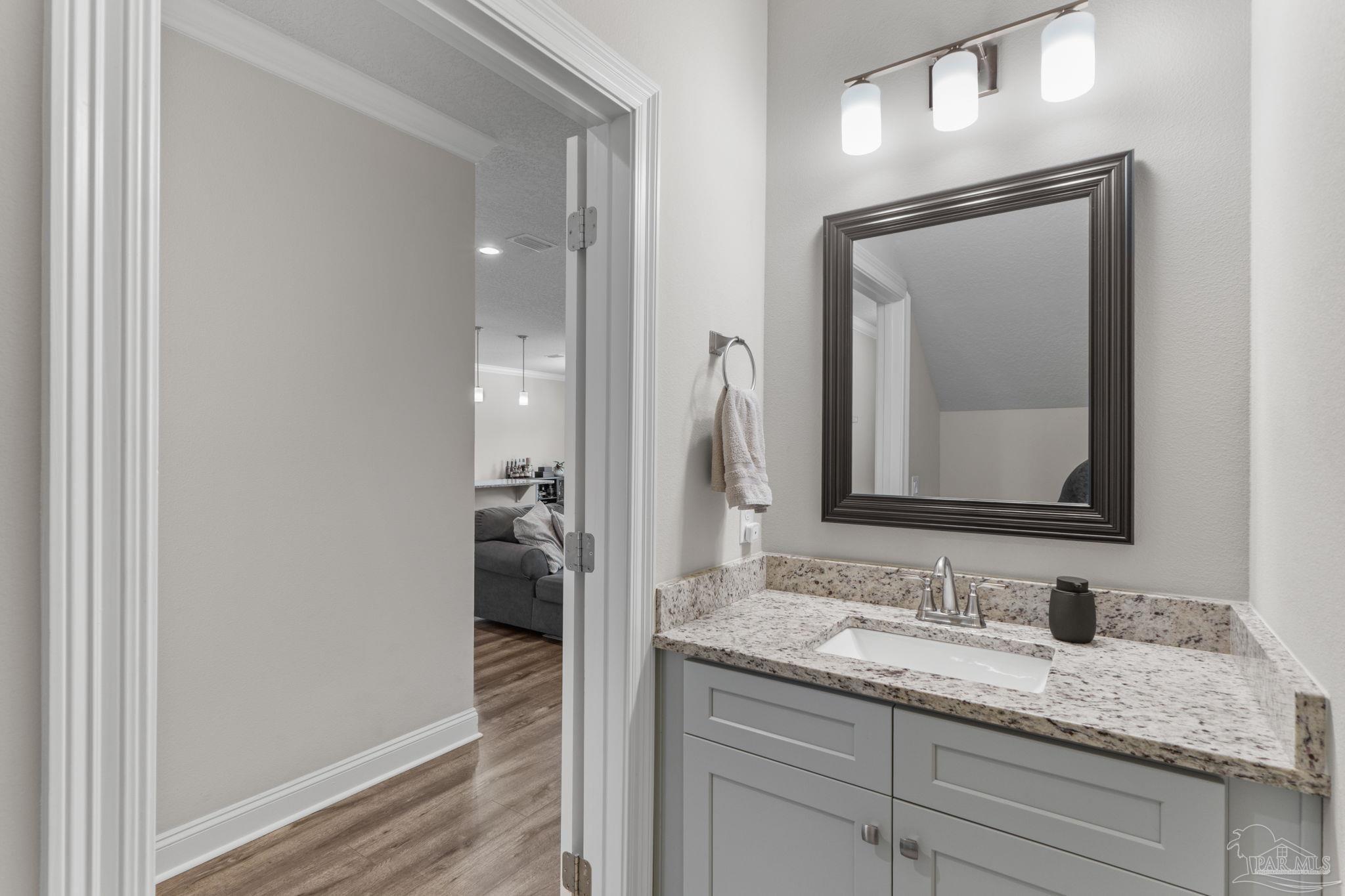2770 Joe Pruitt Road Navarre, FL 32566 - Photo 43 of 58 a bathroom with a granite countertop sink vanity and mirror