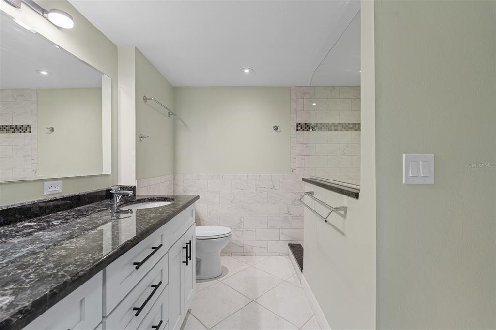 14770 Eagle Ridge Drive, Unit 112 Fort Myers, FL 33912 - Photo 13 of 32 a bathroom with a granite countertop sink toilet and mirror
