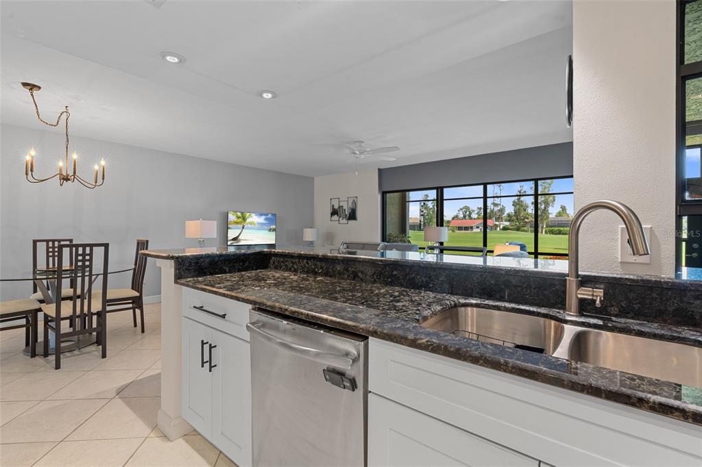 14770 Eagle Ridge Drive, Unit 112 Fort Myers, FL 33912 - Photo 7 of 32 a kitchen with granite countertop a sink and a window