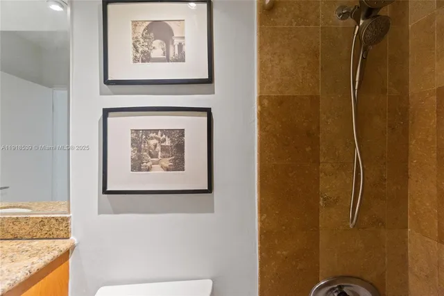 a bathroom with a granite countertop sink a mirror and a shower