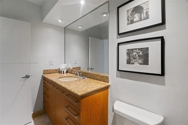 a bathroom with a granite countertop sink and a mirror