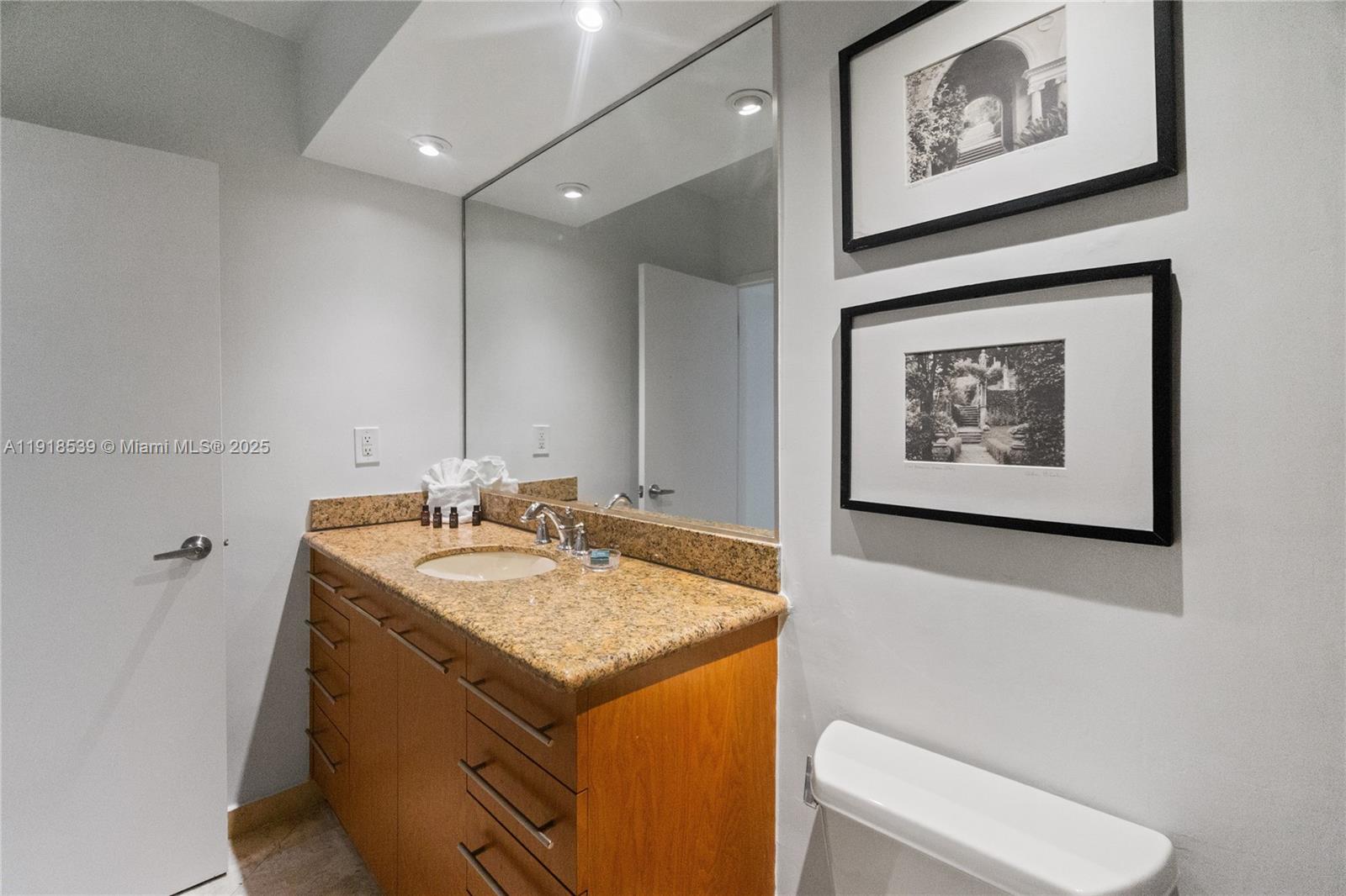 Miami Beach City Center Miami Beach, FL 33139 - Photo 15 of 15 a bathroom with a granite countertop sink and a mirror