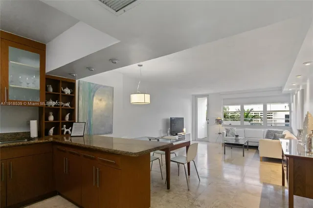 a open kitchen with granite countertop a table and chairs in it