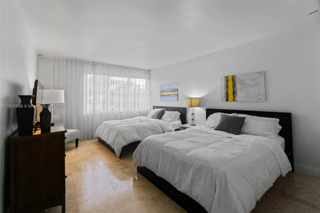 a bedroom with two beds and painting on the wall