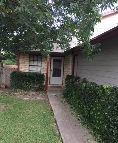 a front view of a house with a yard and potted plants