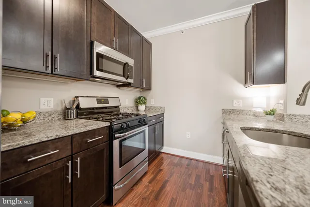 a kitchen with stainless steel appliances granite countertop a sink and refrigerator