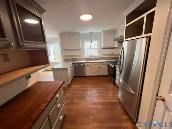 a kitchen with stainless steel appliances granite countertop a refrigerator and a stove