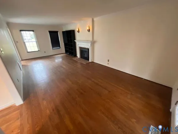 an empty room with wooden floor and fireplace