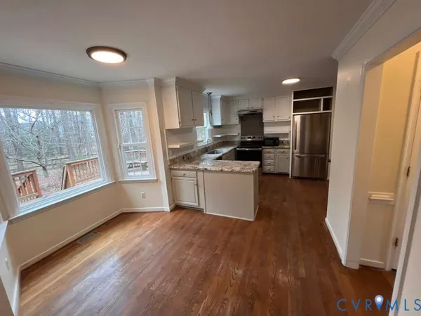 a kitchen with stainless steel appliances a stove a sink a refrigerator a window and cabinets
