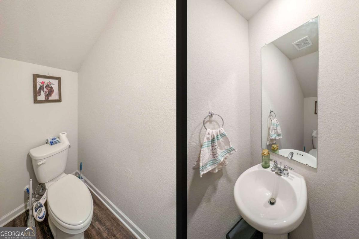 653 Meadows Farm Way Monroe, GA 30655 - Photo 17 of 34 a bathroom with a toilet sink and mirror