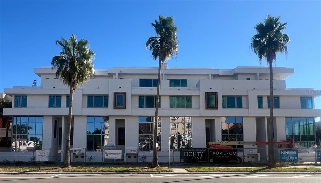 a view of a building with a yard and potted plants
