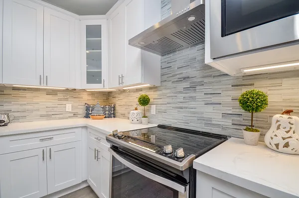 a kitchen with a stove and white cabinets