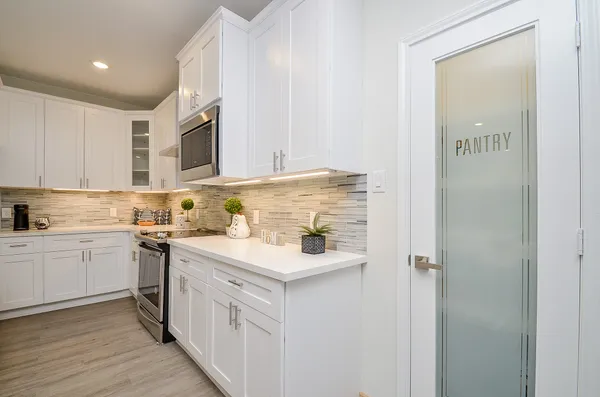 a kitchen with a sink cabinets and wooden floor