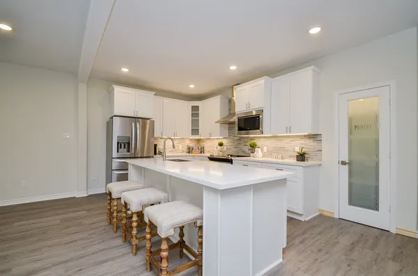 a kitchen with a sink a microwave a refrigerator and cabinets