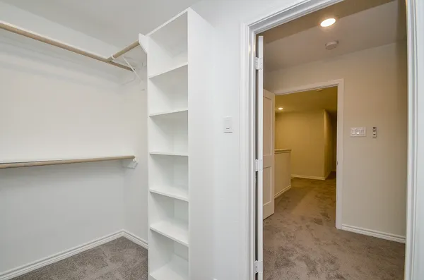 a view of an empty walk in closet and a bathroom