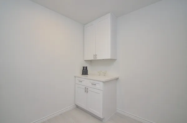 a room with white cabinets and sink