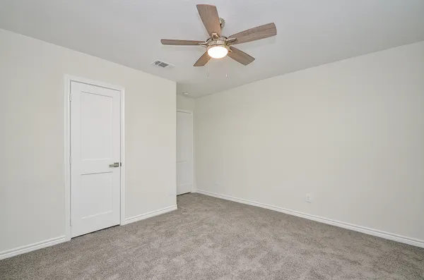 an empty room with closet and windows