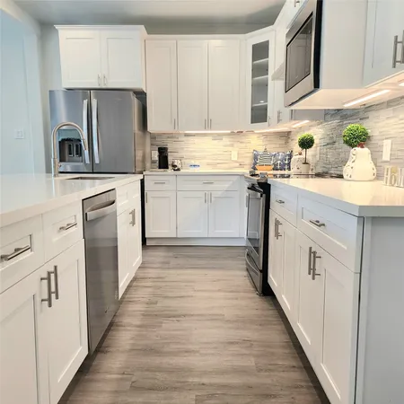 a kitchen with white cabinets and white appliances