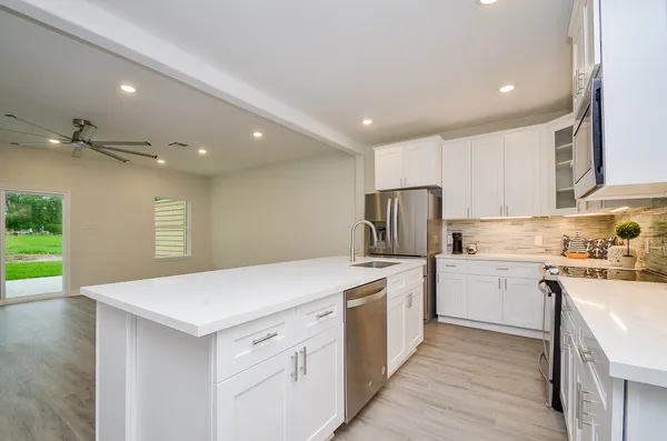 a kitchen with a sink a stove and cabinets