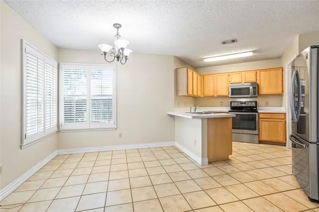 a kitchen with granite countertop a stove a sink and a microwave