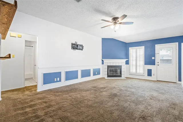 a view of a livingroom with a ceiling fan fireplace and windows