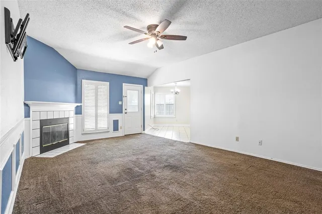 a view of an empty room with a fireplace and a window