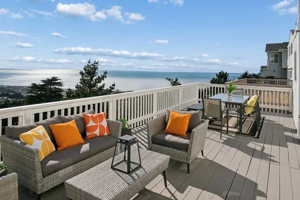 a balcony with wooden floor and outdoor seating