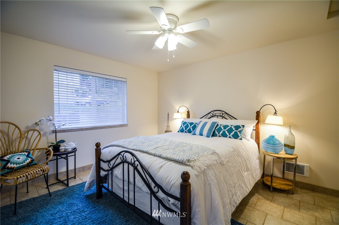 23920 Brier Road Brier, WA 98036 - Photo 14 of 23 a bedroom with a bed and a chandelier