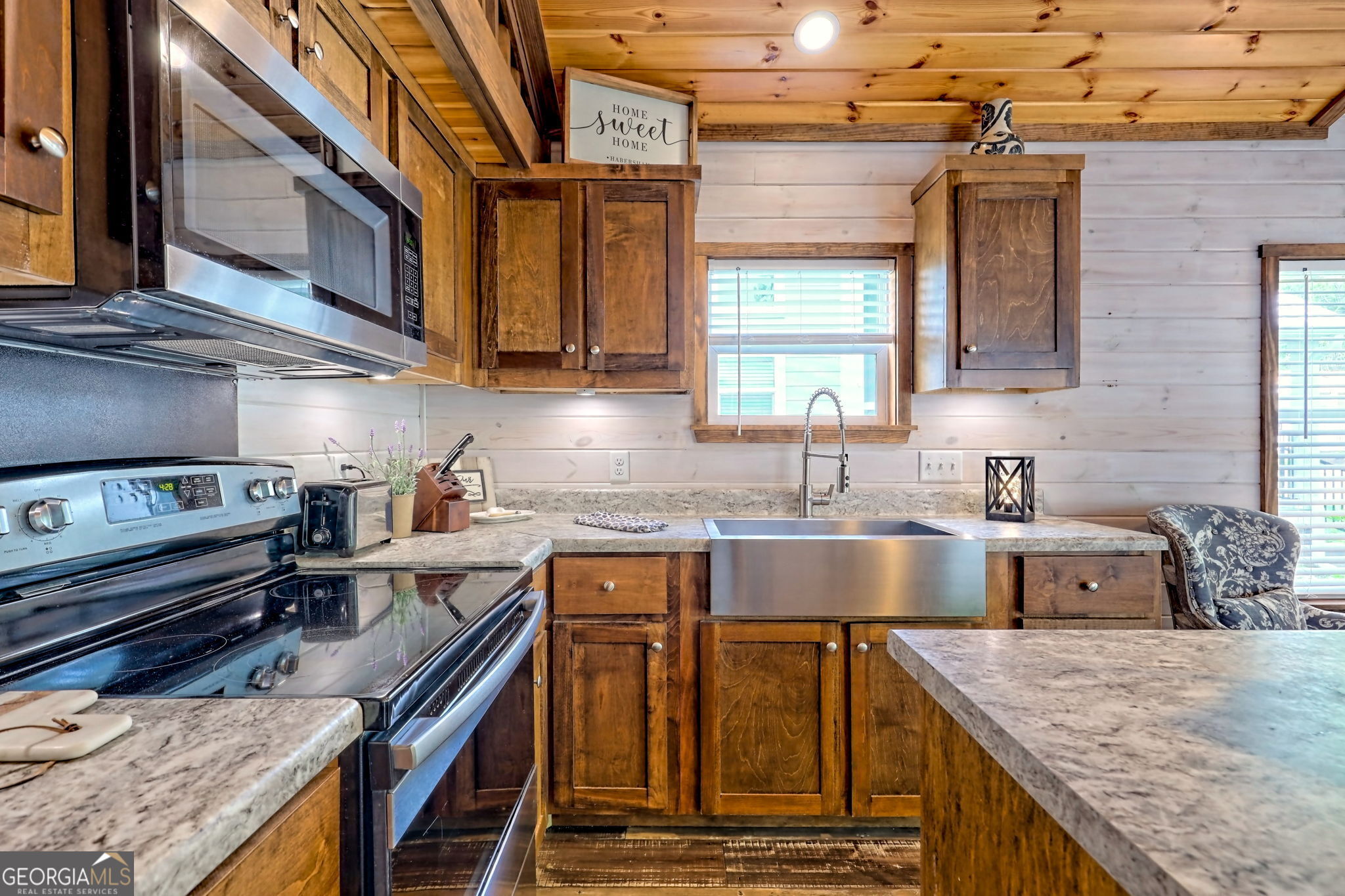 4960 Laurel Lodge Road Clarkesville, GA 30523 - Photo 8 of 29 a kitchen with stainless steel appliances granite countertop a sink a stove and a wooden cabinets